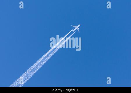 Les avions laissant traînée trace sur un ciel bleu clair Banque D'Images