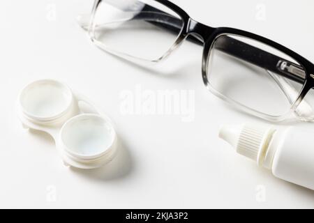 Composition de lunettes avec gouttes pour les yeux et boîtier pour lentilles de contact sur fond blanc Banque D'Images