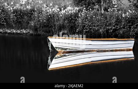 Une image en noir et blanc avec une touche de couleur d'un bateau et son reflet sur l'eau, l'atmosphère sombre et sinistre, l'aspect vintage, horizontal Banque D'Images