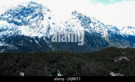 Czarny Staw Pod Rysamy ou lac Black Pond près de la cabane de montagne Morskie Oko Snowy dans les montagnes polonaises de Tatry, vue sur les drones, Zakopane, Pologne. Vue aérienne prise de magnifiques collines verdoyantes et montagnes dans des nuages sombres et reflet sur le lac Morskie Oko. Destination touristique de voyage Banque D'Images