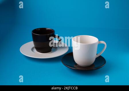 photo de la tasse blanche et de la tasse brune avec soucoupes Banque D'Images