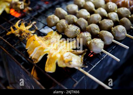 Boulettes de viande et calmars grillées avec un bâton de bambou sur la cuisinière, barbecue de style thaïlandais Banque D'Images