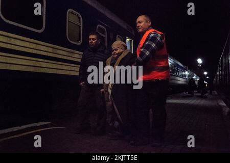 Kherson, Ukraine. 23rd novembre 2022. Le personnel de la gare a aidé une femme avec un bâton de marche à monter dans le train d'évacuation. Malgré les troupes ukrainiennes qui libérent la ville de Kherson, dans le sud du pays, le gouvernement a décidé d'évacuer ses habitants par train et par autobus vers d'autres villes. L'évacuation est venue comme la lutte intense entre les côtés russe et ukrainien et la ville manque d'un approvisionnement de base en eau et en électricité. (Photo par Ashley Chan/SOPA Images/Sipa USA) crédit: SIPA USA/Alay Live News Banque D'Images