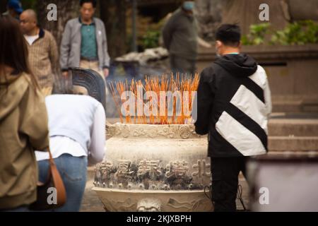 Personnes éclairant des bâtons d'encens au temple en Chine Banque D'Images