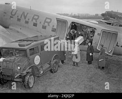 Les secours de déchargement fournis par l'UNRRA à Varsovie, en Pologne, en 1946. Les caisses de fournitures médicales sont transférées d'un avion cargo à un camion portant le logo (polonais) de l'UNRRA. L'UNRRA (Administration des Nations Unies pour les secours et la réhabilitation) était un organisme international de secours (de 1943 à 1948). L'agence a distribué environ $4 milliards de biens, de nourriture, de médicaments, d'outils et d'outils agricoles en période de graves pénuries et de difficultés de transport aux victimes de la guerre dans les zones sous le contrôle des Nations Unies – une photographie vintage de 1940s. Banque D'Images