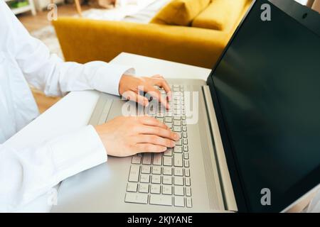 Jeune femme utilisant un ordinateur portable dans l'intérieur moderne. Indépendant travaillant à distance depuis sa maison. Jeune femme d'affaires écrivant un e-mail. Vue en gros plan de Banque D'Images