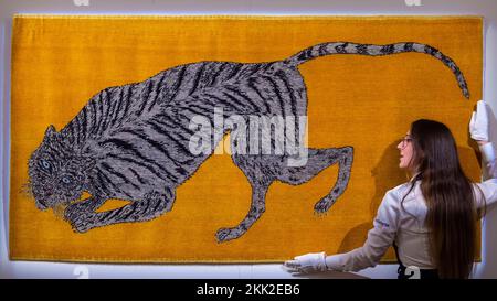 Londres, Royaume-Uni. 25 novembre 2022. Un technicien avec « bonds » de Kiki Smith à un avant-goût des « Tigers de demain », une exposition caritative à Sotheby's New Bond Street. 12 artistes se sont inspirés du tapis de tigre tibétain pour créer un modèle unique de tapis d'art à l'aide de techniques traditionnelles. Les tapis sont exposés le 24-29 novembre à côté d'une exposition sur le thème du tigre par des artistes avec des bénéfices de tous les fonds de collecte de ventes pour le WWF (World Wildlife Fund). Credit: Stephen Chung / Alamy Live News Banque D'Images