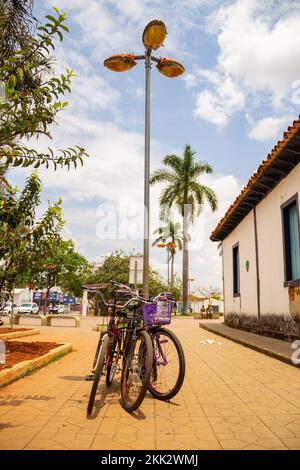 Aparecida de Goias, Brésil – 23 octobre 2022 : trois bicyclettes attachées au poteau avec une chaîne sur une place de ville. Banque D'Images