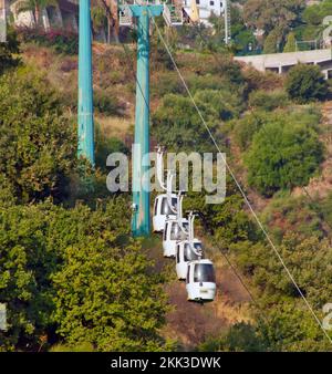 Une ligne de téléphériques montant une colline verte Banque D'Images