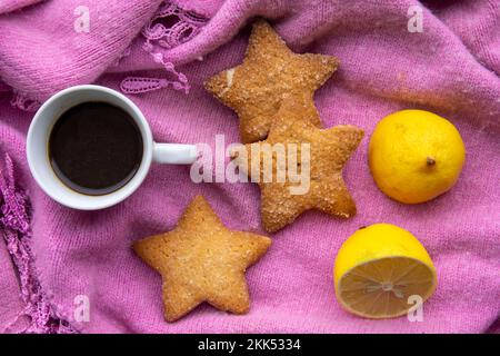 Café avec biscuits et citron sur un foulard d'hiver Banque D'Images