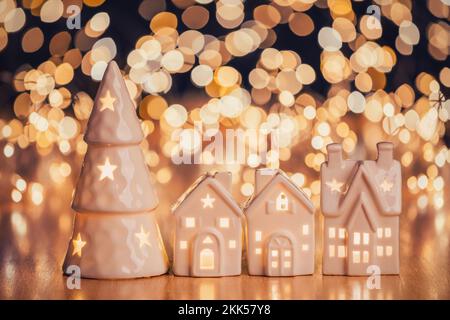 Maison en céramique et arbre de noël sur fond à pois lumineux Banque D'Images