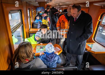 Oberwiesenthal, Allemagne. 25th novembre 2022. Les familles jouent à divers jeux de dés lors de la mise en service de la nouvelle voiture de jeu de la Fichtelbergbahn. C'est la première voiture de jeu sur un chemin de fer à voie étroite saxonne. La Sächsische Dampfeisenbahngesellschaft (SDG) a investi 11 500 euros dans la conversion et la conception de la voiture. Credit: Kristin Schmidt/dpa/Alay Live News Banque D'Images