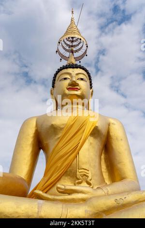 Vue à angle bas de la statue de bouddha doré sur un ciel bleu avec des nuages arrière-plan au temple bouddhiste historique Wat Chiang Yuen, Chiang Mai, Thaïlande Banque D'Images