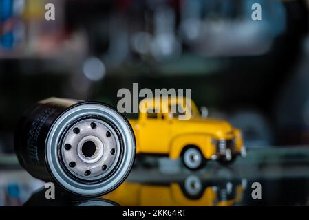 Filtre à huile moteur avec fond jaune de voiture de camion dans le magasin, concept de service d'entretien de pièces automobiles. Banque D'Images