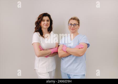 Portrait de deux cosmétologues qualifiés, des femmes souriant en toute confiance dans un centre médical Banque D'Images