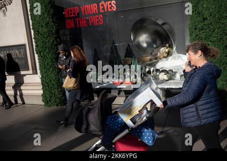 Les clients marchent devant une vitrine de Noël à Selfridges, le Black Friday, sur Oxford Street, le vendredi 25th novembre 2022, à Londres, en Angleterre. Banque D'Images