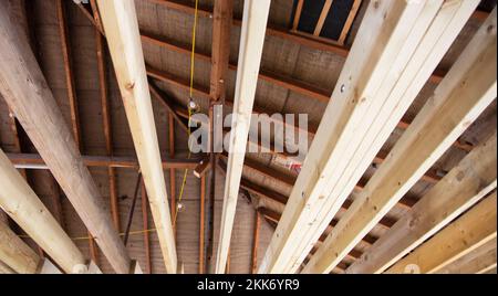 Vue intérieure de poutres apparentes de plafond en bois et de charpente dans un bâtiment en construction ou en rénovation Banque D'Images