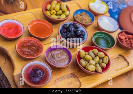Table de petit-déjeuner turc. Pâtisseries, légumes, légumes verts, olives, fromages, oeufs frits, épices, confitures, miel, thé en pot de cuivre et verres de tulipe, larges Banque D'Images