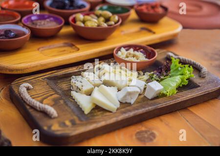 Petit-déjeuner turc. Pâtisseries, légumes, légumes verts, olives, fromages, oeufs frits, épices, confitures, miel, thé en pot de cuivre et verres de tulipe, larges Banque D'Images