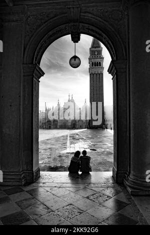 Venise, Italie - 5 juillet 2021 : le couple observe le lever du soleil sur la place Saint-Marc avec vue sur la basilique Saint-Marc à la lumière du matin. Banque D'Images