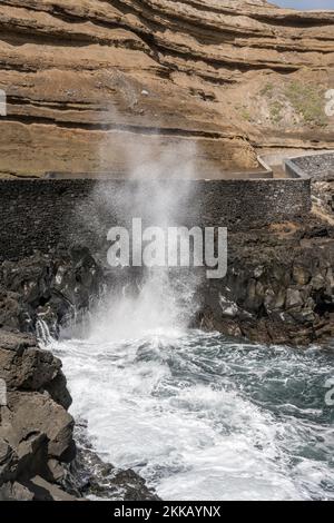 Paysage avec vagues de l'océan se précipitant sur les falaises volcaniques de l'île de Madère, photographié dans la lumière d'automne lumineuse à Porto de Cruz, Portugal Banque D'Images