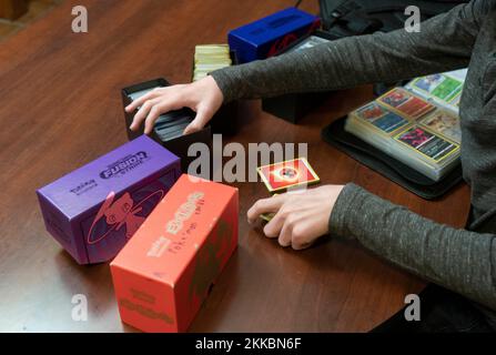 Austin Texas Etats-Unis, 24 novembre 2022: Garçon de 14 ans trie sa collection de cartes Pokémon pendant une pause dans les activités de Thanksgiving dîner dans la maison d'un parent. ©Bob Daemmrich Banque D'Images