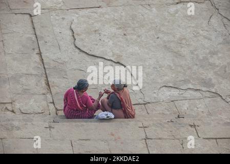 Delhi, Inde - DEC 11, 2011: Deux vieilles femmes indiennes pauvres s'assoient à l'étage et discutent. Ils appartiennent à la caste des Shudras, les ouvriers. Banque D'Images