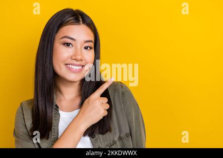 Gros plan portrait de jeune gai souriant mignon indonésien doigt direct maquette nouveau centre commercial ouverture isolée sur fond jaune Banque D'Images