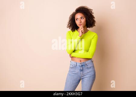 Photo portrait de belle jeune femme cheveux ondulés visage sceptique ne crois pas habillés vêtements tendance jaune isolés sur fond beige couleur Banque D'Images