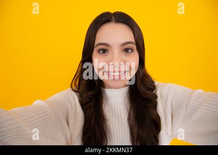 Drôle adolescente faisant le selfie posant sur fond jaune. Banque D'Images