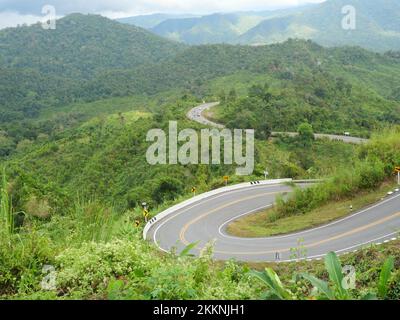 Vue aérienne de la montagne et forêt tropicale pleine d'arbre vert, courbe de route Alpha dans la vallée à Pua District, province de Nan, Thaïlande Banque D'Images