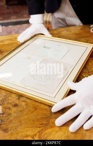 Leinfelden Echterdingen, Allemagne. 25th novembre 2022. La maison de vente aux enchères Eppli à Stuttgart, outre d'autres objets sur le thème de la « royauté britannique », une lettre manuscrite de deux pages de la Reine Elizabeth II (1926-2022) récemment décédée de 1966 à un équestre passionné. Ferdinand Eppli présente l'objet à mettre aux enchères. C'est la lettre encadrée, une copie du dos et de l'enveloppe. Crédit : Julian Rettig/dpa/Alay Live News Banque D'Images