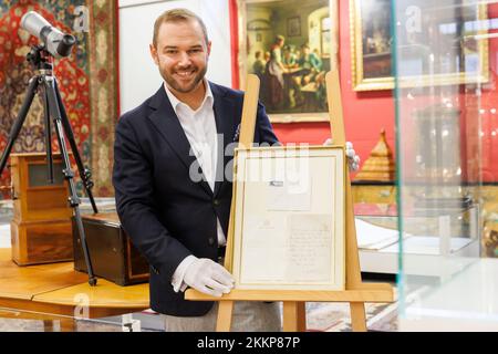 Leinfelden Echterdingen, Allemagne. 25th novembre 2022. La maison de vente aux enchères Eppli à Stuttgart, outre d'autres objets sur le thème de la « royauté britannique », une lettre manuscrite de deux pages de la Reine Elizabeth II (1926-2022) récemment décédée de 1966 à un équestre passionné. Ferdinand Eppli (membre de la direction de l'entreprise familiale Eppli) présente l'objet à mettre aux enchères. C'est la lettre encadrée, une copie du dos et de l'enveloppe. Crédit : Julian Rettig/dpa/Alay Live News Banque D'Images