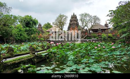 L'architecture reconnaissable des temples balinais. La porte d'entrée du temple est à travers un jardin avec un étang et des nénuphars. Banque D'Images