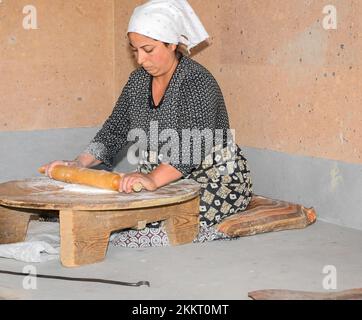 Les femmes cuisent du pain de lave typiquement arménien dans le four de terre 'tonir', Abovyan, Arménie Banque D'Images