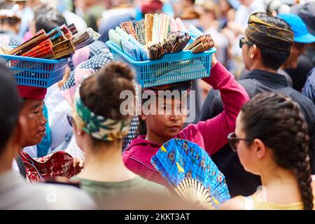 Un vendeur de rue porte ses marchandises sur sa tête. Un moyen de porter des poids sur la tête. Bali, Indonésie - 03.02.2018 Banque D'Images