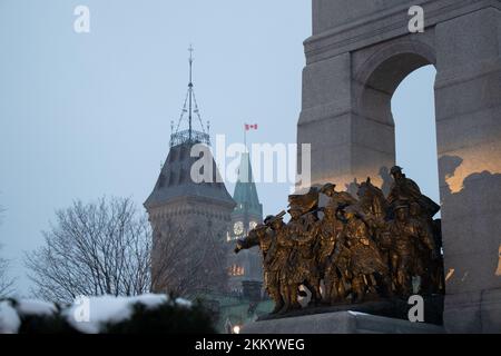 Un après-midi enneigé, le Mémorial national de guerre, dans la capitale du Canada, Ottawa, est éclairé. La tour de la paix du Parlement dans le fond. Banque D'Images