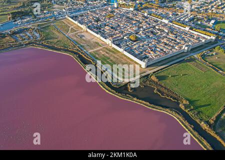 Vue aérienne du magnifique lac rose et de la production de sel de la Camargue en face du village d'Aigues mortes Banque D'Images