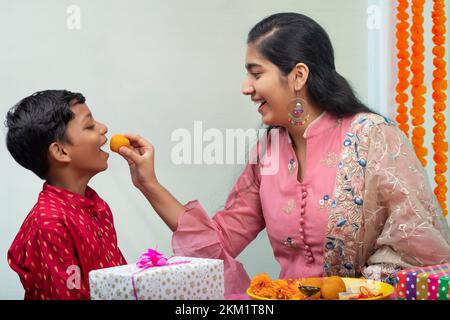 Sœur qui noue rakhi au poignet de son frère à l'occasion de Raksha Bandhan Banque D'Images