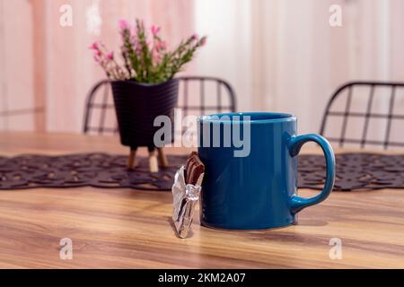 Tasse de café et chocolat sur table en bois contre le rideau et le fond de chaise. Vue latérale, espace de copie, gros plan. Cuisine table à manger, concept pause Banque D'Images