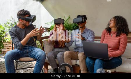 Groupe de jeunes amis qui vivent une expérience de réalité virtuelle avec un casque, une femme pilotant l'AR, des influenceurs expérimentés et des joueurs essayant un nouveau virtuel Banque D'Images