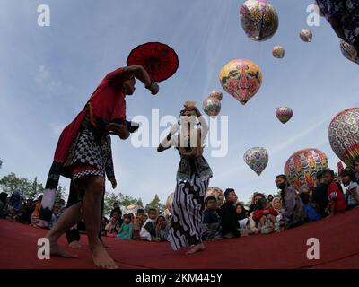 Les danseurs Lengger de Wonosobo Regency, Central Java, Indonésie dansent sur fond de ballons à air chaud Banque D'Images