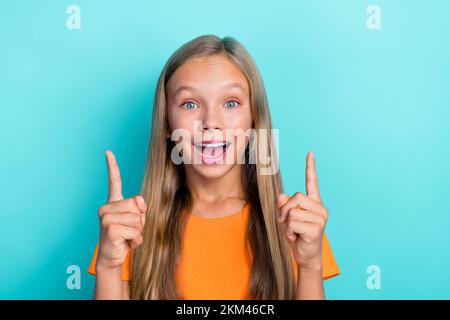 Photo de la petite fille surjoyée élégant vêtements bras direct vide espace recommander visite bas prix boutique vente isolé couleur cyan fond Banque D'Images