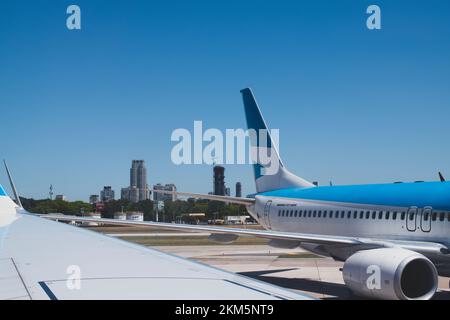L'extrémité arrière d'un grand avion, garé à la porte, avec la ville de Buenos Aires en arrière-plan. Banque D'Images
