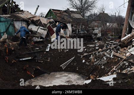 Kramatorsk, Ukraine. 19th novembre 2022. Les résidents locaux qui marchent près d'un cratère alors qu'ils inspectent leur maison qui a été endommagée après les bombardements russes à Kramatorsk. Les infrastructures énergétiques de l'Ukraine sont de nouveau attaquées par la Russie cette semaine, laissant des millions de personnes sans pouvoir. Alors que les températures descendent en dessous du point de congélation dans tout le pays, il y a des craintes que Moscou - qui a du mal à gagner la guerre qu'elle a commencée - soit « l'hiver de l'armement ». Et il n'est nulle part plus clair à quoi cela pourrait ressembler que dans les villes situées le long de la ligne de front à l'est. (Credit image: © Andriy Andriyenko/SOPA Images via ZUMA Press Wire) Banque D'Images