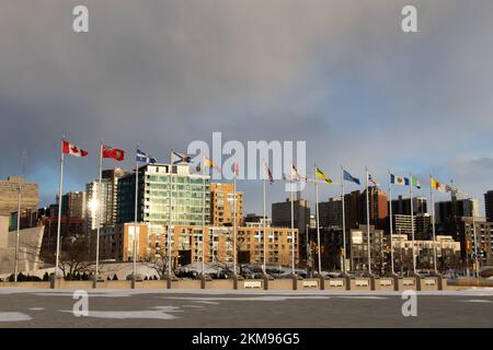 Le drapeau du Canada et les 13 provinces et territoires sont vus devant le Mémorial de guerre du Canada, le soleil de l'après-midi qui brille au large du centre-ville d'Ottawa Banque D'Images