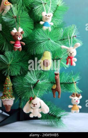 Gros plan sur des jouets en crochet colorés. Décorations de Noël faites à la main. Jouets amigurumi mignons. Banque D'Images