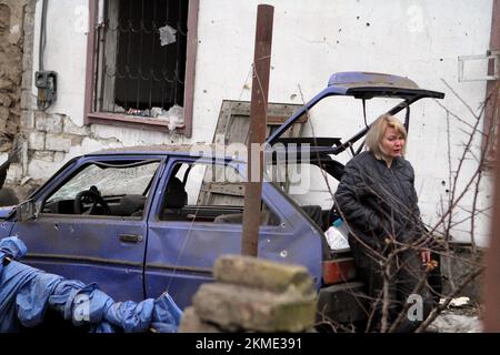 DNIPRO, UKRAINE - le 26 NOVEMBRE 2022 - Une femme se penche contre une voiture endommagée à la suite d'une attaque de fusée russe contre Dnipro, en Ukraine centrale. Comme on l'a signalé, six personnes ont été blessées et sept maisons privées ont été partiellement détruites. Banque D'Images