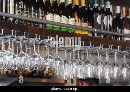 Bouteilles de vin sur le plateau en bois et verres à vin sur un rack dans le restaurant, Londres Angleterre Royaume-Uni Banque D'Images