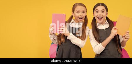 Filles d'école amis. Lisez-moi l'histoire. Les enfants surpris tiennent des livres sur fond jaune. Littérature pour enfants. Portrait d'une jeune fille étudiante, bannière de studio Banque D'Images